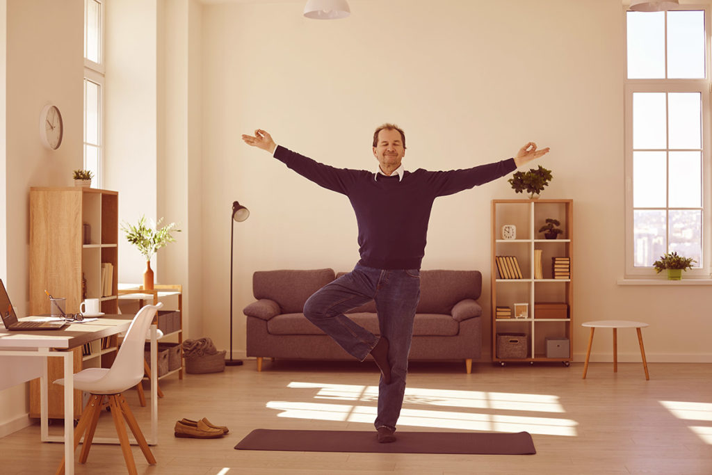 Man doing yoga from home office, good employee experience