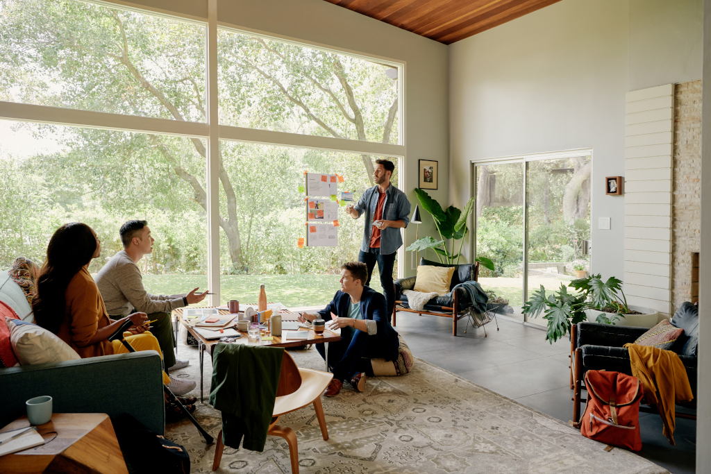 People having a business meeting in a home provided by Airbnb, as one of the examples of great employee experience