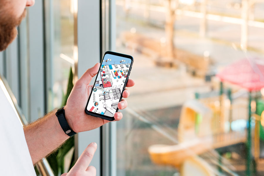 man holding a smart phone that has a digital twin office map with free and occupied desk for hybrid works