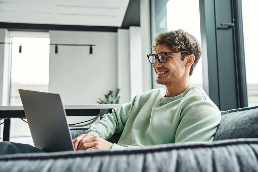 man smiling with laptop